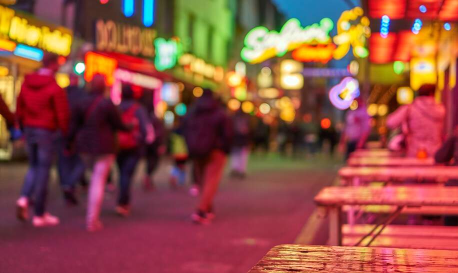 Reeperbahn bei Nacht defokussiert mit leuchtenden Schildern | © Gettyimages.com/Thomas Demarczyk