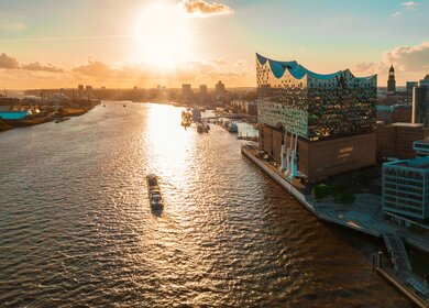 Luftaufnahme vom Wasser auf der Hamburger Hafenstadt mit der Elbphilharmonie zur goldenen Stunde | © Gettyimages.com/golero