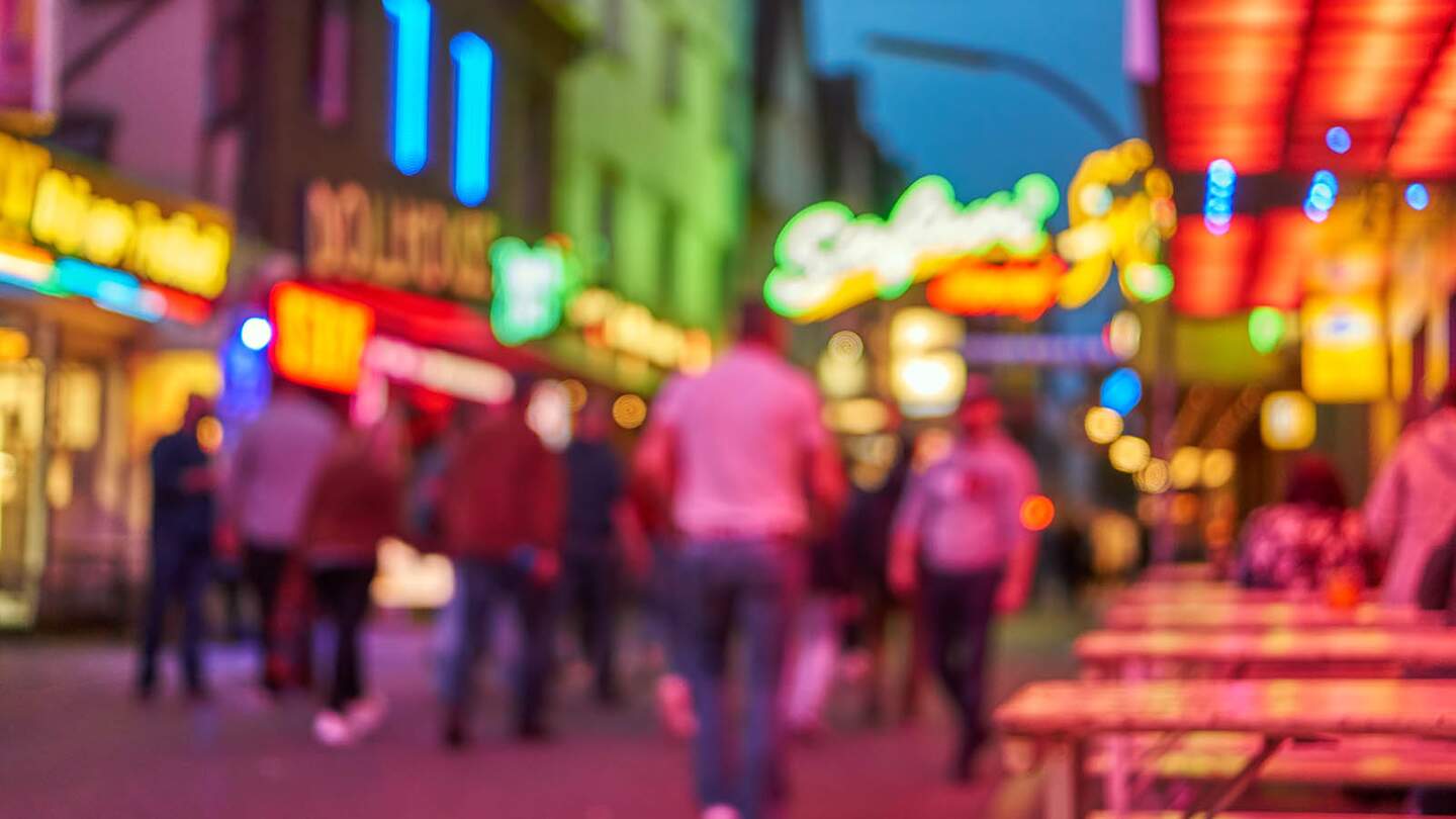Reeperbahn bei Nacht defokussiert mit leuchtenden Schildern | © Gettyimages.com/ThomasDemarczyk