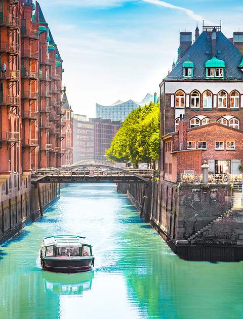 Speicherstadt in Hamburg mit einem Tourboot auf dem Wasser | © gettyimages.com