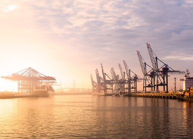 Hamburger Hafen Container-Terminal bei Sonnenuntergang | © Gettyimages.com/mf-guddyx