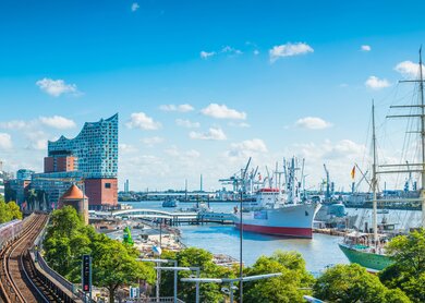 Panoramablick über die Uferpromenade im Zentrum Hamburgs, von den Landungsbrueckenvillen ueber das ikonische Gebaeude der Elbphilharmonie bis zu den Schiffen im geschaeftigen Hafen des Hamburger Hafens | ©  Gettyimages.com/fotoVoyager