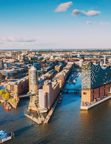 Luftaufnahme der Hamburger Hafenstadt ueber dem blauen Hafen  | © Gettyimages.com/Nikada