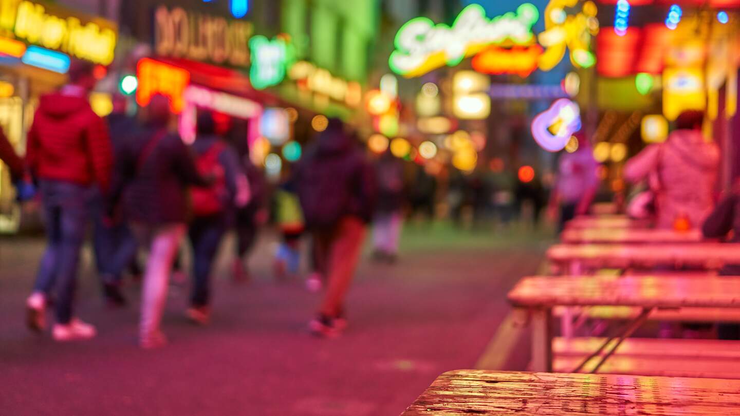 Reeperbahn bei Nacht defokussiert mit leuchtenden Schildern | © Gettyimages.com/Thomas Demarczyk