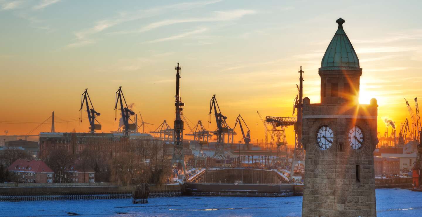 St. Pauli an Hafen von Hamburg bei Sonnenuntergnag mit Kraenen im Hintergrund | © Gettyimages.com/cinoby