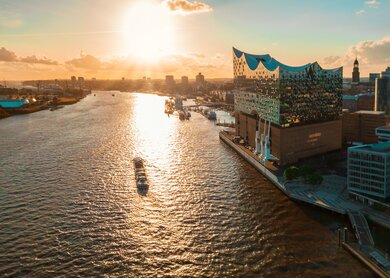 Luftaufnahme vom Wasser auf der Hamburger Hafenstadt mit der Elbphilharmonie zur goldenen Stunde | © Gettyimages.com/golero