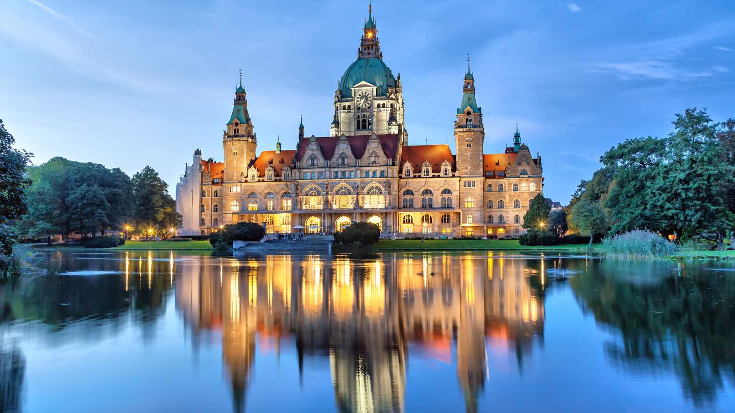 Blick auf beleuchtete Neue Rathause in Hannover am Abend mit See im Vordergrund  | © Gettyimages.com/bbsferrari