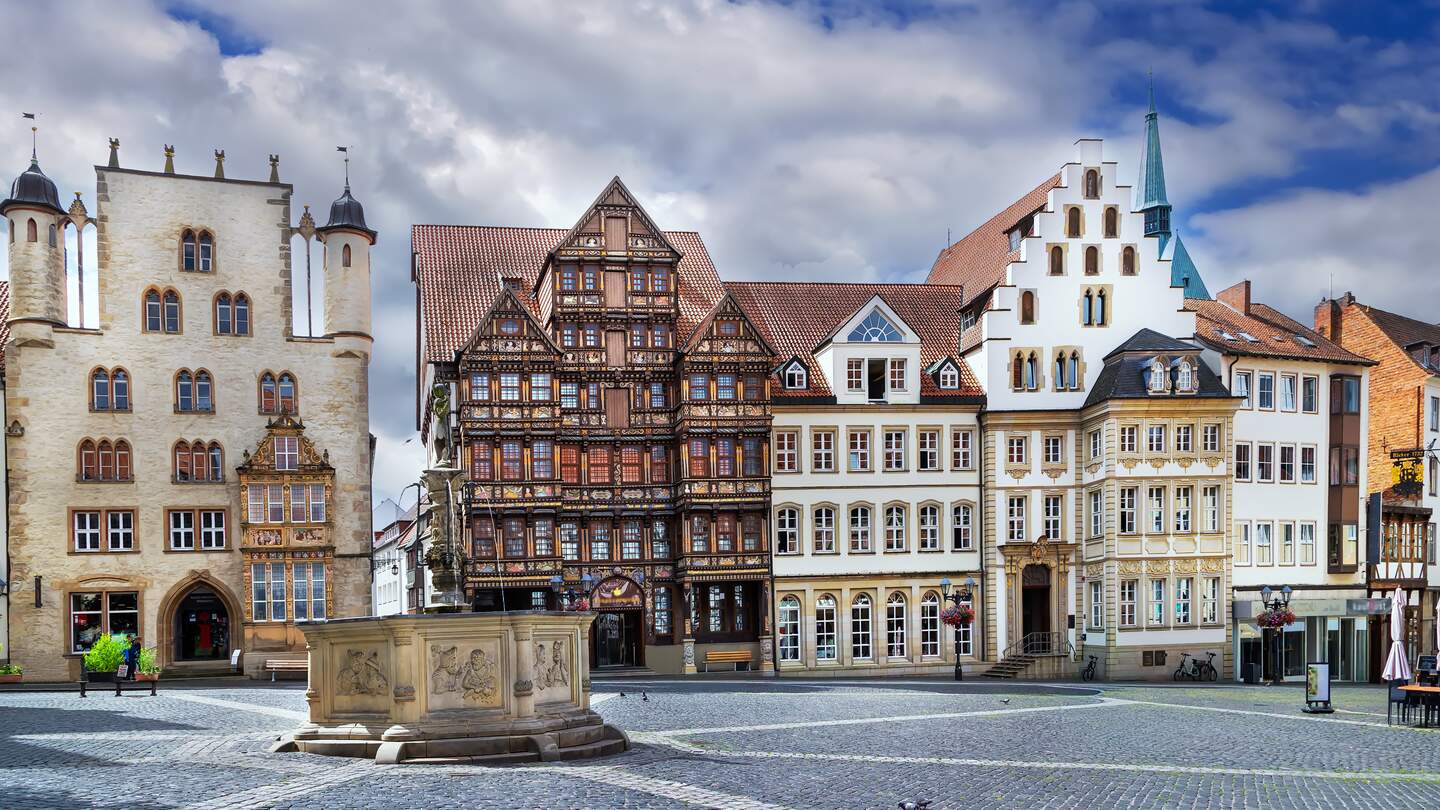 Der Marktplatz in Hildesheim mit seinen zahlreichen historischen Fachwerkhäusern im Vorgrund ein historischer Brunnen | © GettyImagse.com/Borisb17