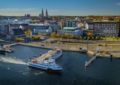 Panorama der Kieler Innenstadt und des Hafens mit Linienfaehre. Kieler Foerdemuseum Hafen im Vordergrund, im Hintergrund das Kieler Schloss. | © Gettyimages.com/frederickdoerschem