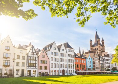 Bunte Häuser und ein Park in Köln. der Kirchturm im Hintergrund.  | © Gettyimages.com/jotily