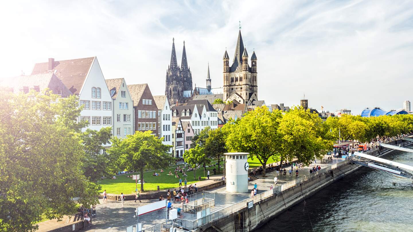 Menschen laufen auf der Rheinpromenade in Köln, der Blick auf die Kölner Altstadt | © Gettyimages.com/querbeet