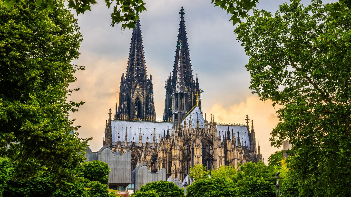 Kölner Dom in Köln, aufgenommen vom Fuße des Doms mit Bäumen im Vordergrund | © Gettyimages.com/Jan de Waal