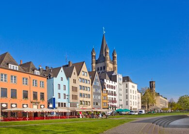 Alte Gebaeude am Rheinufer in Köln mit St. Martin Kirche bei blauem Himmel | © Gettyimages.com/walencienne