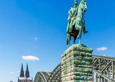Denkmal von Wilhelm dem I. in der Naehe der Hohenzollernbruecke und des Koelner Doms in der Stadt Koeln | © Gettyimages.com/rclassenlayouts