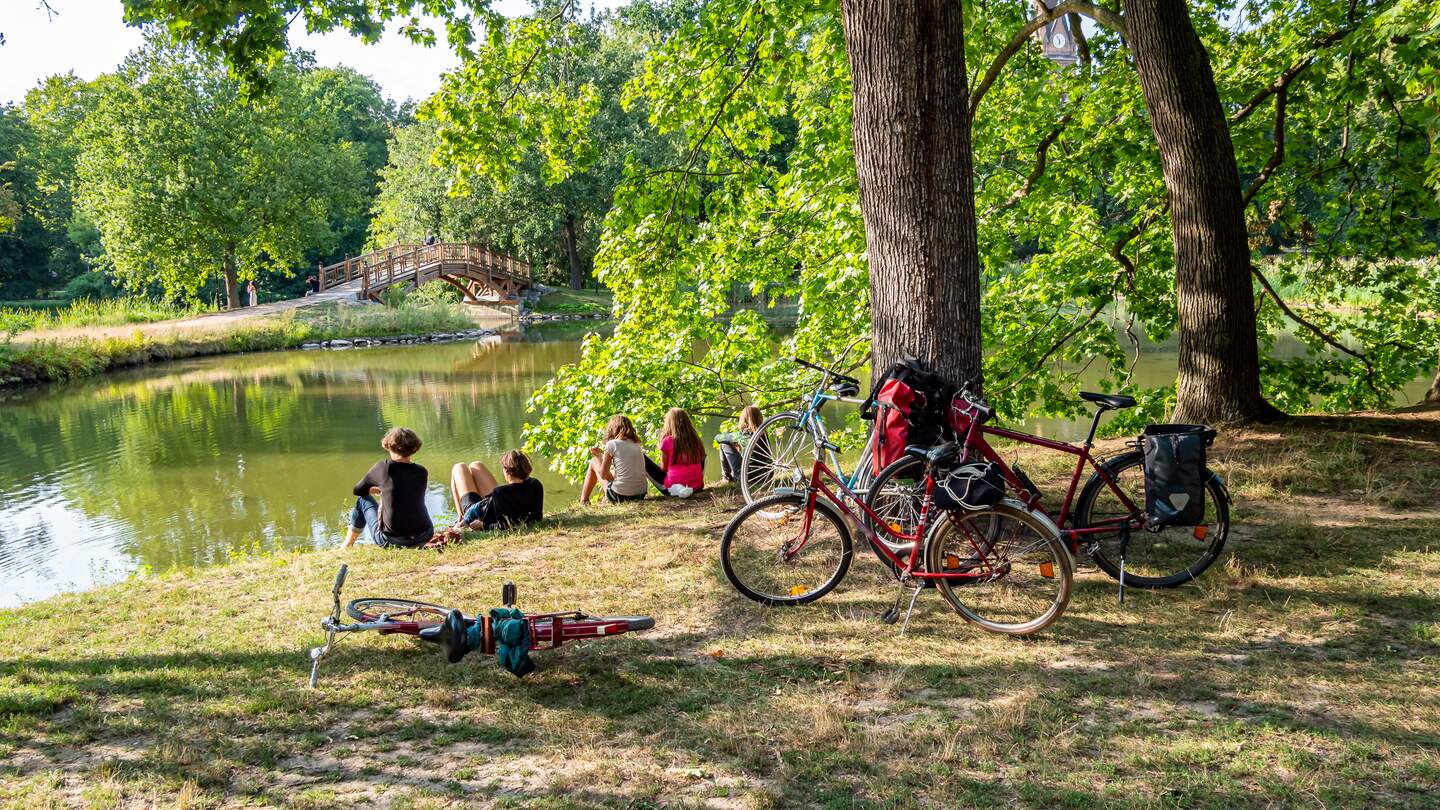 Freunde, die eine Auszeit im Clara Zetkin Park im Sommer in Leipzig machen.  | © Gettyimages.com/Animaflora