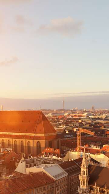 Stadtueberblick von Muenchen mit Frauenkirche und Marienplatz bei Sonnenuntergang | © Gettyimages.com/alexsl