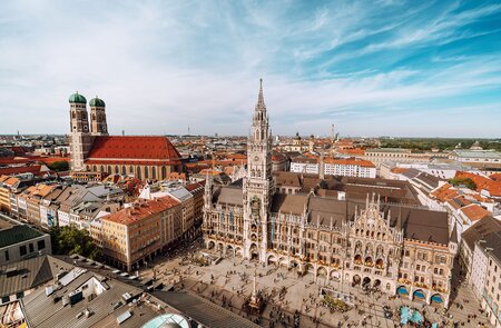  eine Luftaufnahme des Marienplatzes, dem zentralen Platz in Muenchen, mit dem Neuen Rathaus und seiner aufwendigen gotischen Fassade sowie den Zwillingstuermen der Frauenkirche im Hintergrund. | ©  Gettyimages.com/Nikada