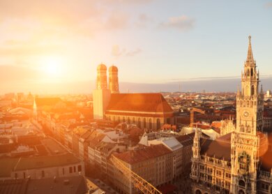 Stadtueberblick von Muenchen mit Frauenkirche und Marienplatz bei Sonnenuntergang | © Gettyimages.com/alexsl