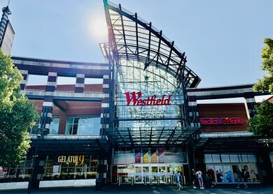 Westfield Centro Shoppingcenter Eingangsbereich von außen aus Glas mit rotem Logo | © Michelle Khan