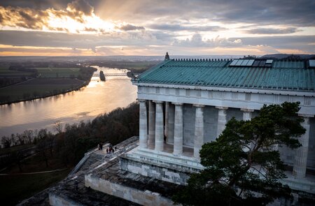 Szenische Aufnahme des Walhalla-Denkmals in Regensburg und der Donau bei Sonnenuntergang | © Gettyimages.com/Wirestock