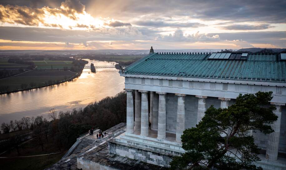 Szenische Aufnahme des Walhalla-Denkmals in Regensburg und der Donau bei Sonnenuntergang | © Gettyimages.com/Wirestock