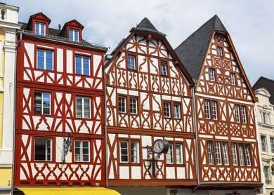 Fassaden von Fachwerkhaeusern der Altstadt in Trier mit bewoelktem Himmel | © Gettyimages.com/KarSol