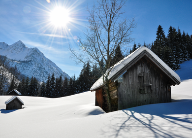 In Bad Hindelang im Allgäu ist eine Hütte in einer winterlichen Berglandschaft. | © GettyImages/marima-design