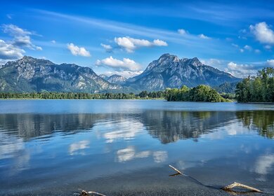 Blick ueber den Foggernsee auf das Schloss Neuschwanstein mit herrlich blauem Himmel | © Gettyimages.com/magann