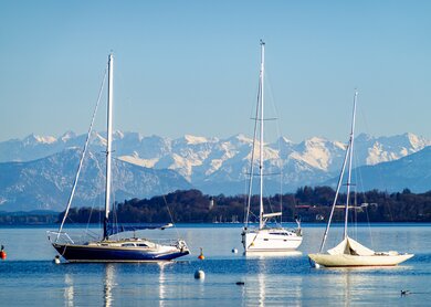 Blick auf Segelboote auf dem Starnbergersee in Bayern mit Bergpanorama | © Gettyimages.com/FooTToo