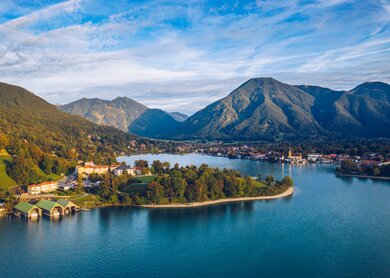 Blick auf den Tegernsee in Rottach-Egern bei Sonnenschein und leichter Bewoelkung | © Gettyimages.com/DaLiu
