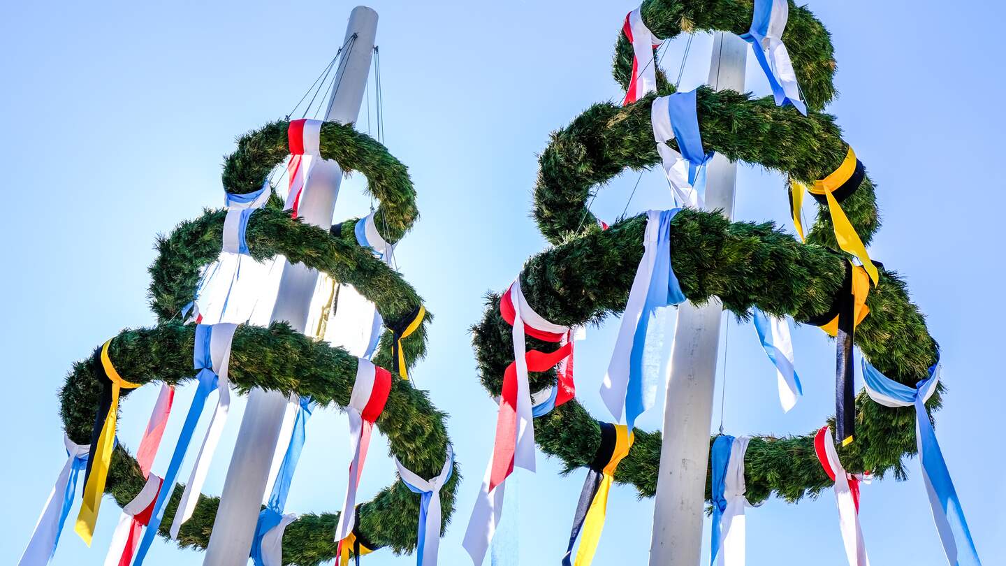 Typischer Bayrischer Maibaum mit Kraenzen und bunten Baendern | © Gettyimages.com/FooTToo