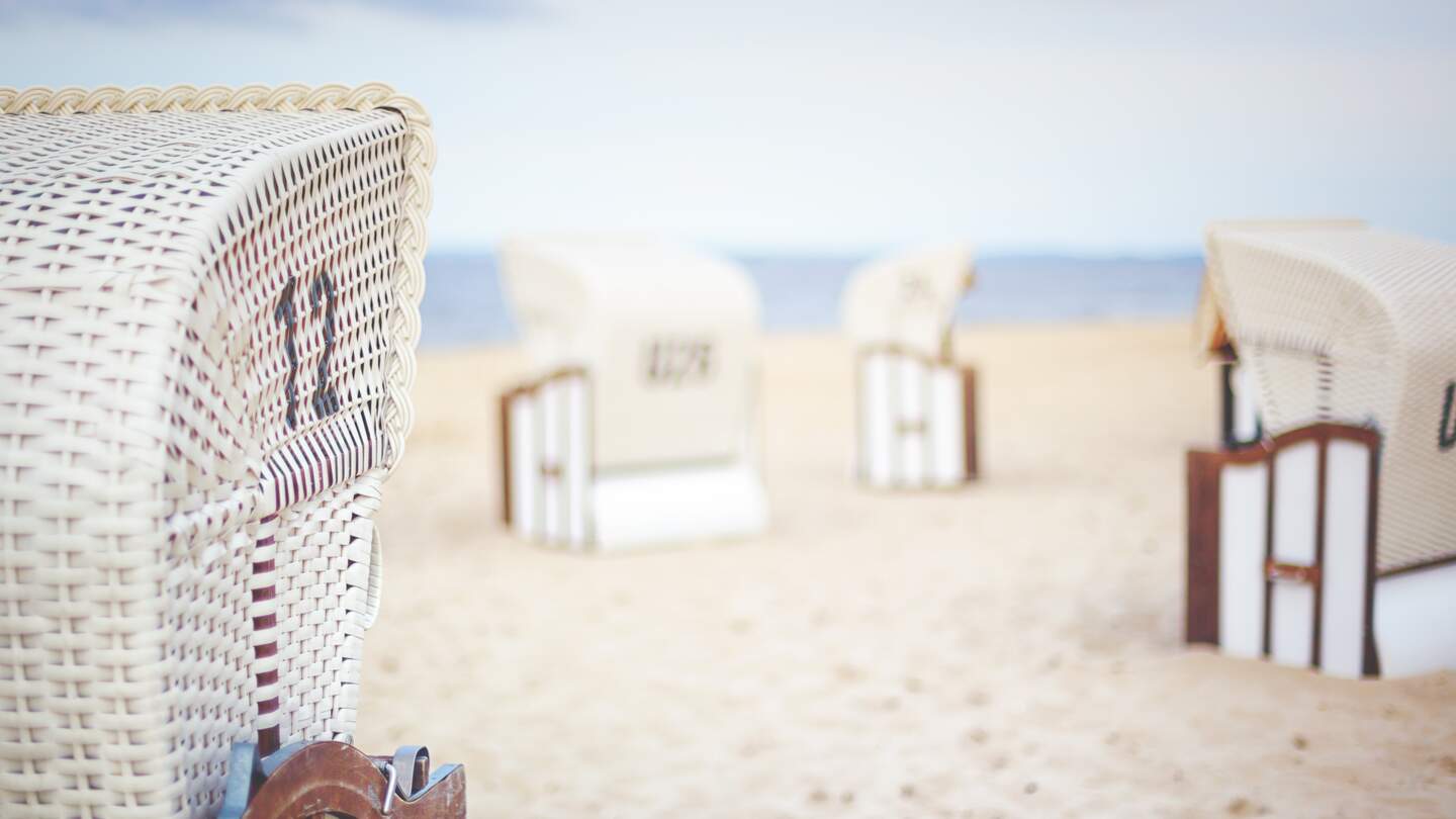  Strandkorbs aus Korbgeflecht, mit weiteren aehnlichen Stuehlen im Hintergrund  | © gettyimages.com/Rike_