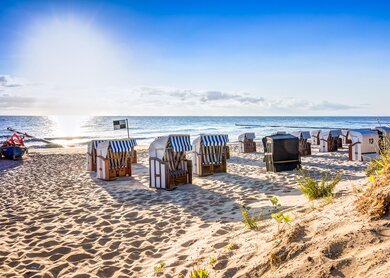  einen Sandstrand mit mehreren traditionellen Strandkoerben, die zum Meer hin ausgerichtet sind | ©  Gettyimages.com/mije_shots