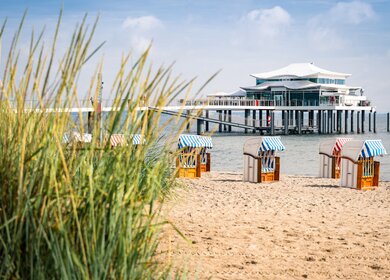 Seebruecke mit Restaurant in Timmendorfer Strand, Ostsee, mit Strandhafer und Strankoerben im Vordergrund | ©  Gettyimages.com/Steffen_F