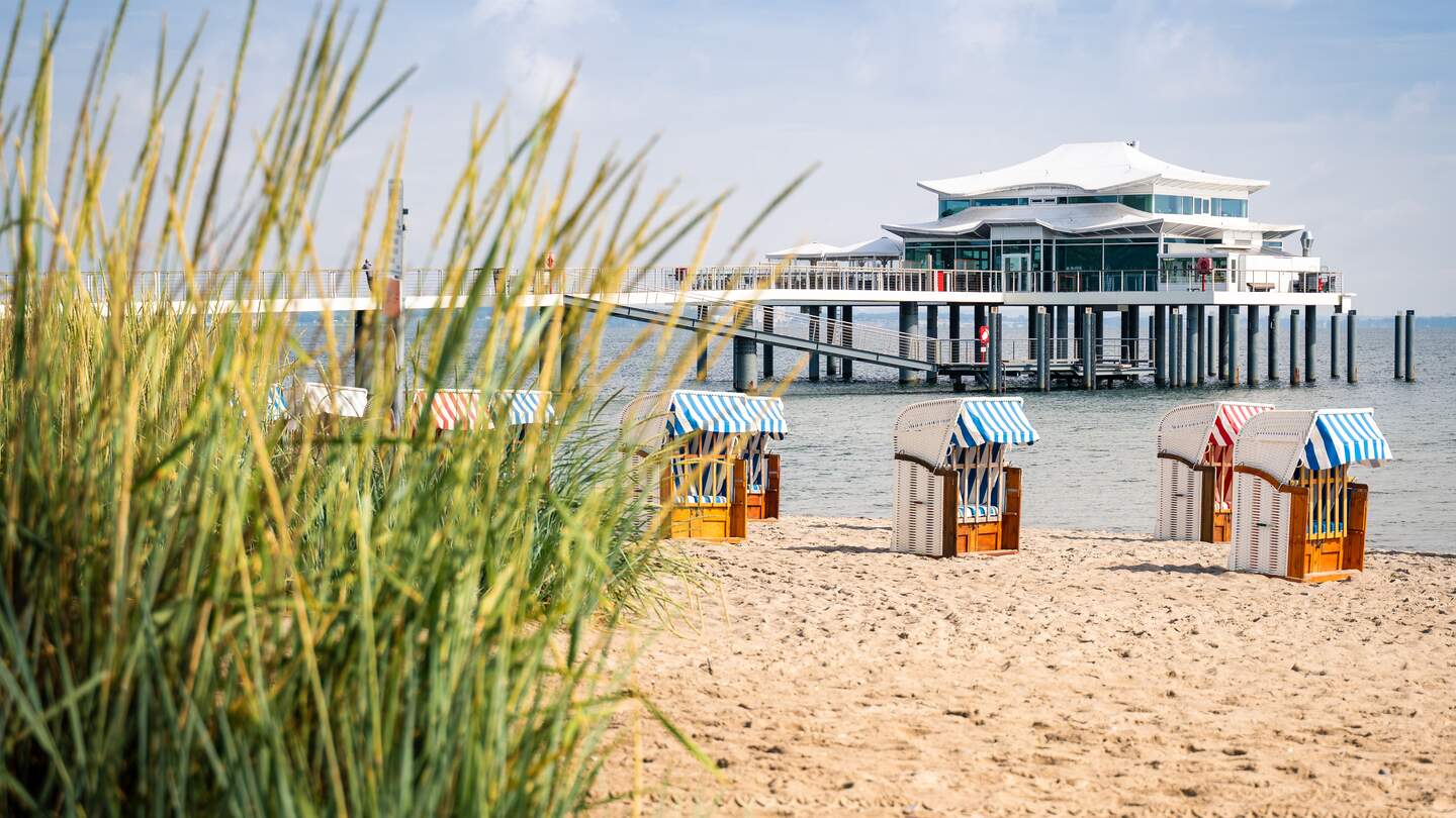 Seebrücke mit Restaurant in Timmendorfer Strand, Ostsee, mit Strandhafer und Strankörben im Vordergrund | © © Gettyimages.com/Steffen_F