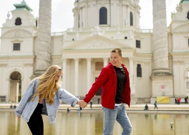 Ein junges Paar geht an der katholischen Kirche St. Peter in Wien vorbei | © Gettyimages.com/boggy22
