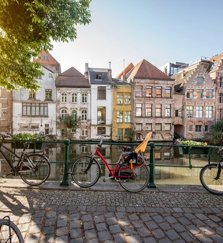 Blick auf eine Gracht mit wunderschönen historischen Gebäuden und Fahrrädern in sommerlichem Morgenlicht in Gent, Flandern, Belgien | © Gettyimages.com/RossHelen