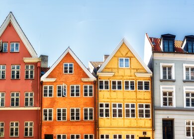 Frontale Ansicht Kopenhagener Nyahavn - Bunte traditionelle dänische Häuser mit hellblauem Himmel | © GettyImage.com/atosan