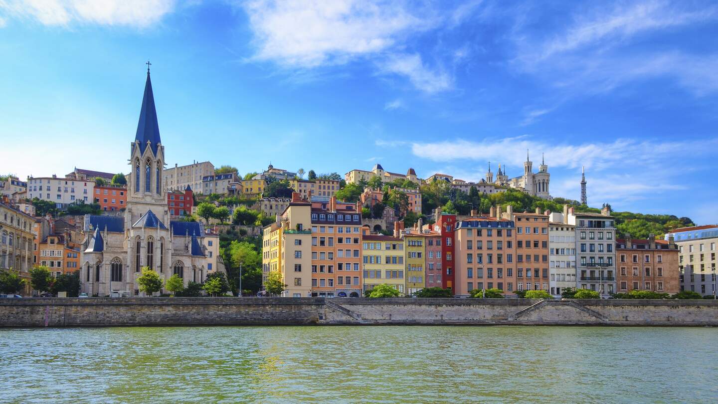 Lyoner Stadtbild von der Saone mit bunten Häusern und Fluss und der Kirche Saint-Georges | © Gettyimages.com/MartinM303
