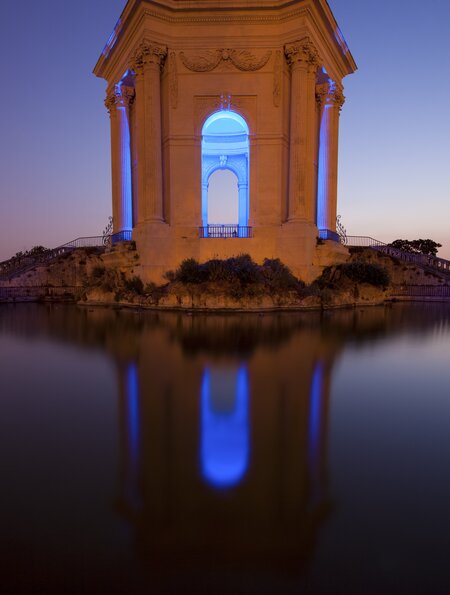 Beleuchtetes Chateau d ' Eau, Wasserturm am Ende des Aquädukts in Montpellier bei Nacht | © Gettyimages.com/davidevison