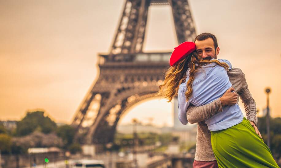 Junges Paris, die ihre Liebe vor dem Eiffelturm in Paris teilen  | © Gettyimages.com/AleksandarNakic