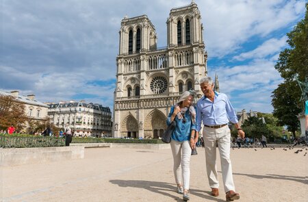 Glückliches Seniorenpaar vor der Kathedrale Notre-Dame in Paris mit einem wunderbaren Urlaub | © Gettyimages.com/LeoPatrizi