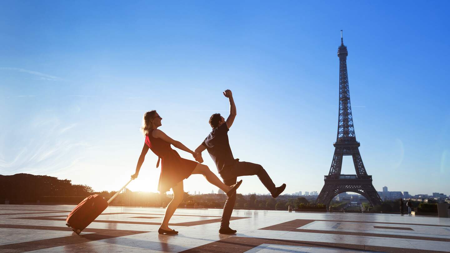 Verrücktes Touristenpaar  auf Städtereise in Paris, Mann und Frau haben Spaß mit Gepäck in der Nähe des Eiffelturms | © © Gettyimages.com/anyaberkut