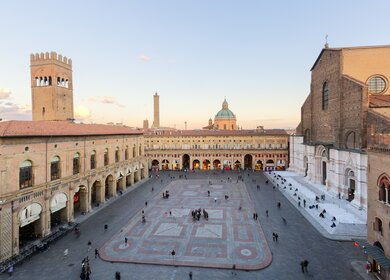 Touristen aus aller Welt für die Piazza Maggiore mit der basilika San Pietrino und der Torre dell’Arengo | © Gettyimages.com/minoandriani