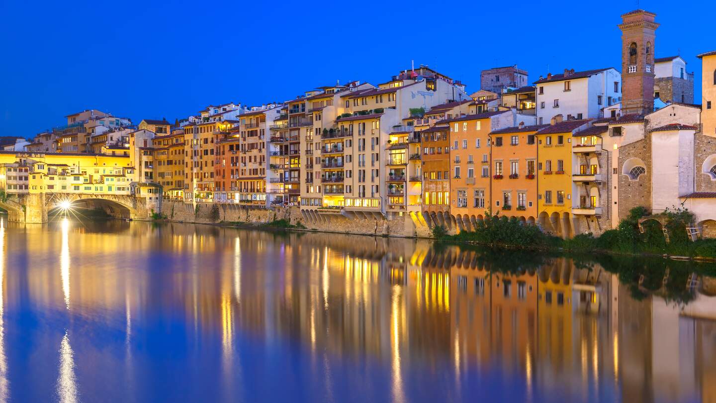 Alte Häuser und Turm am Ufer des Flusses Arno und Ponte Vecchio bei Nacht, Florenz | © Gettyimages.com/KavalenkavaVolha