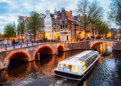 Abendliche Rundfahrt durch die beleuchteten Grachten in Amsterdam | © Gettyimages.com/Eloi_Omella