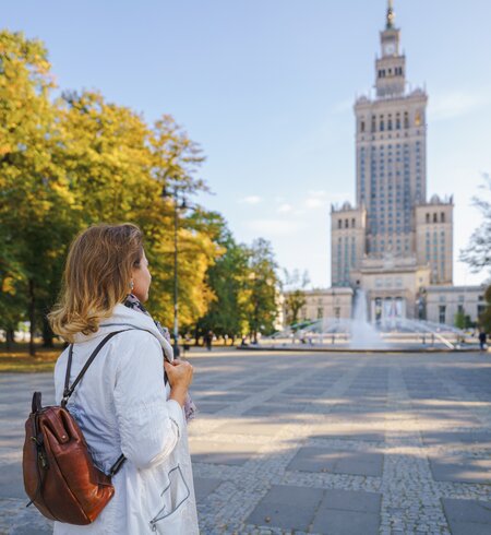 Frau schaut sich den Palast der Kultur und Wissenschaft in Warschau im Herbst | © Gettyimages.com/pawel.gaul