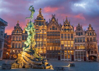 Grote Markt von Antwerpen, Belgien in der Daemmerung.. Man sieht die Zunfthaeuser und einen Brunnen | © Gettyimages.com/seanpavone