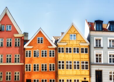 Frontale Ansicht Kopenhagener Nyahavn - Bunte traditionelle daenische Haeuser mit hellblauem Himmel | © GettyImage.com/atosan