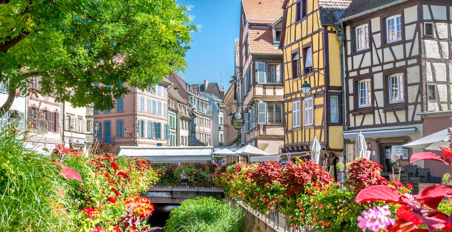 Altstadt von Colmar mit Blick auf den Fluss Lauch und Blumen im Vordergrund | © Gettyimages.com/adisa